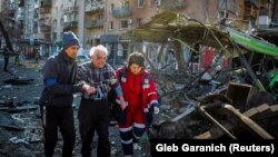 Mentősök támogatnak egy sérültet Kijev bombázása után március 14-én
