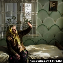 Masha sits in her house in the village of Gorelovka.