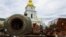 A child plays on top of an exhibition of destroyed Russian military vehicles and weapons outside St. Michael's Cathedral in Kyiv.