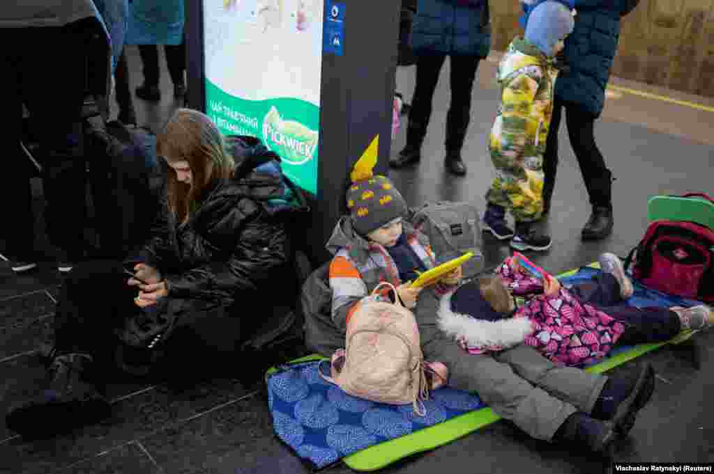 Діти з батьками ховаються всередині однієї зі станцій метро в Києві під час масованих російських ракетних обстрілів України 16 грудня 2022 року