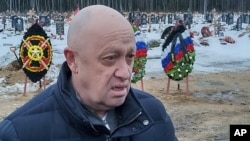 Evgheni Prigojin la înmormântarea unuia dintre mercenarii săi - fostul deținut Dmitri Menșikov, care a murit luptând în Ucraina - la un cimitir din afara Sankt Petersburgului, pe 24 decembrie 2022.