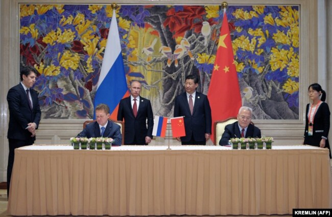 Presidenti kinez, Xi Jinping (djathtas), dhe presidenti rus, Vladimir Putin (majtas), duke vëzhguar ceremoninë e nënshkrimit të marrëveshjes në Shangai më 2014.