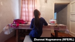 One of Malika Zhangeldieva's daughters does her homework in the family's humble house. ""Most of our income goes for food," Zhangledieva says. "We mend our old clothes and shoes. The kids don't want to wear old stuff all the time, but they understand we have no choice."