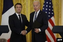 Președintele american Joe Biden și președintele francez Emmanuel Macron își strâng mâinile după o conferință de presă comună în Sala de Est a Casei Albe din Washington, 1 decembrie 2022.