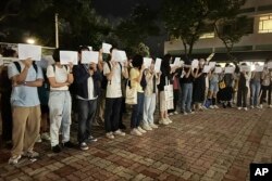 Празните бели листи се превърнаха в символ на протестиращите, които казват, че с тях изразяват всичко, което цензурата на комунистическата власт не им позволява. Снимката е от церемония в памет на жертвите на пожара в Урумчи в Китайския университет на Хонконг, 28 ноември 2022 г.