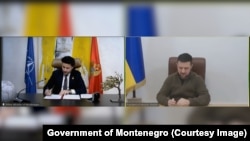 A screen grab of video showing Montenegrin Prime Minister Dritan Abazovic (left) and Ukrainian President Volodymyr Zelenskiy signing a joint declaration on Ukraine's Euro-Atlantic perspective on December 5. 