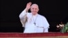 Pope Francis waves to the crowd as he appears at a balcony to deliver his annual Christmas blessing in St. Peter's Square at the Vatican on December 25.