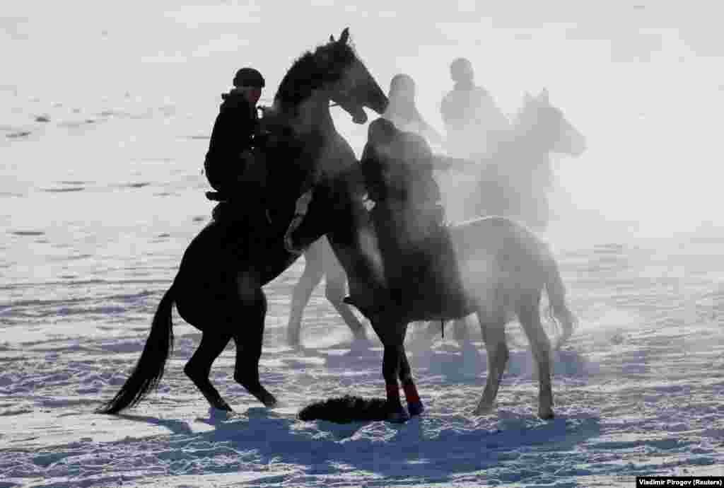 Kyrgyz riders take part in a kok-boru competition on a cold day in the village of Gornaya Maevka, outside Bishkek. Kok-boru is a traditional Central Asian game similar to polo in which horsemen aim to drop the headless carcass of a goat in their opponents&#39; goal.