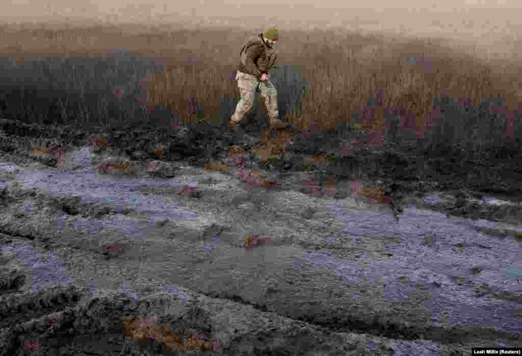 A Ukrainian soldier holding a quadcopter skirts around a muddy rural road in the Donbas region of eastern Ukraine on November 29.&nbsp;