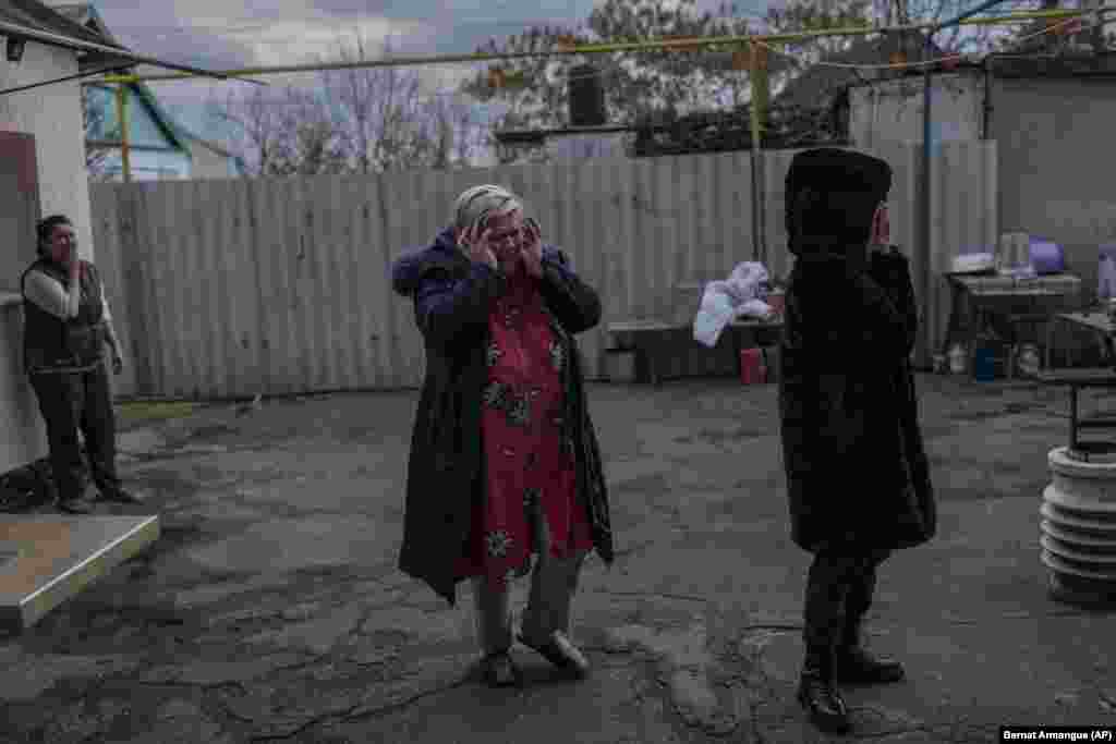 Наталья Вобликова (в центре) плачет из-за того, что ее сын, 13-летний Артур, получил серьезное ранение в результате обстрела российскими войсками их дома в Херсоне. 22 ноября 2022 года