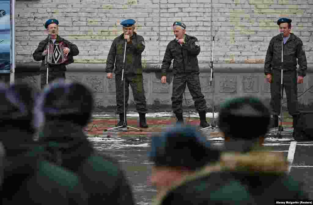 Zenél egy katonabanda a besorozott orosz férfiaknak Omszkban