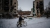 A man pushes his bike next to destroyed residential buildings in Borodyanka, near Kyiv, on December 4.