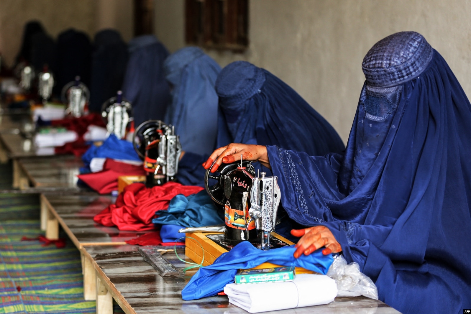 Gratë afgane, të veshura me burka, duke punuar në një rrobaqepësi në Xhalalabad më 1 dhjetor 2022.