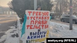 Үкімет отставкасын талап етіп, плакат ұстап тұрған Есанбой Ходжиев. Алматы, 15 желтоқсан 2022 жыл. 