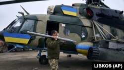Украинский военнослужащий заряжает вертолет на авиабазе недалеко от линии фронта в Херсонской области, 8 января 2023 года