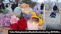 Як повідомляє кореспондент Радіо Свобода, люди несуть іграшки, квіти й лампадки на місце ракетного удару