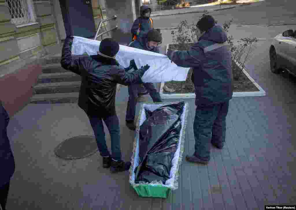 Lucrătorii de la pompele funebre depun un trup neînsuflețit într-un sicriu pe 5 decembrie. Președintele ucrainean Volodimir Zelenski a cerut evacuarea locuitorilor din regiunea estică Donețk la 30 iulie. Cu toate acestea, mulți locuitori au refuzat să plece.