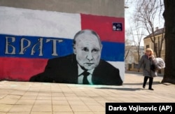 2022. március 12-én, szombaton egy nő halad el egy Vlagyimir Putyin orosz elnököt ábrázoló belgrádi falfestmény mellett, amelyen ez áll: „Testvér”