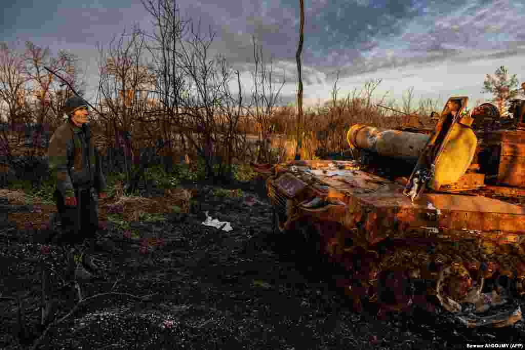 Yuriy Ponomarienko, 54, a resident of Bohorodychne, looks at a destroyed Russian tank, a remnant of the fighting that shattered the community.