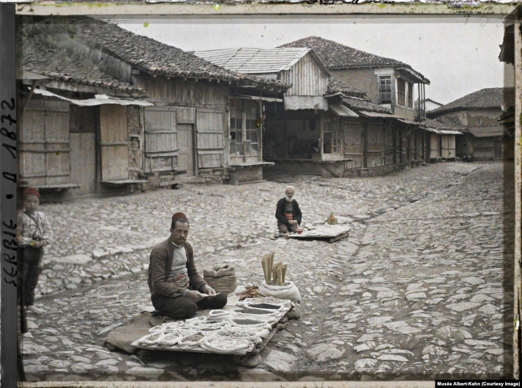 Shitës farërash në kalldrëmin e një rruge në Prishtinë, në Kosovën e sotme, në vitin 1913.