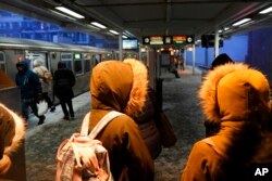 Putnici koji čekaju voz Chicago Transit Authority na stanici za zagrijavanje, 22. decembra 2022., u Čikagu.