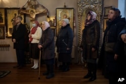 Vjernici u crkvi na božićno jutro, 25. decembra, Bobrytsija, Ukrajina.