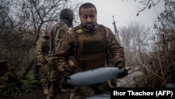 A Ukrainian artilleryman carries a 122-mm shell for a 2S1 Gvozdika self-propelled howitzer at a position along the front line near Bakhmut on December 10.