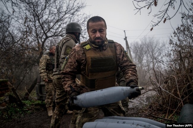 A Ukrainian artilleryman carries a 122-mm shell for a 2S1 Gvozdika self-propelled howitzer at a position along the front line near Bakhmut on December 10.