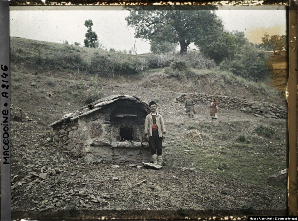 Një burrë duke pozuar pranë furrës së përbashkët të fshatit të tij në Openica, në atë që tani është Maqedonia e Veriut, në vitin 1913.