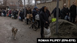 Residents line up to fill bottles with drinking water in the city of Kherson on November 24.