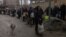 Residents line up to fill bottles with drinking water in the city of Kherson on November 24.