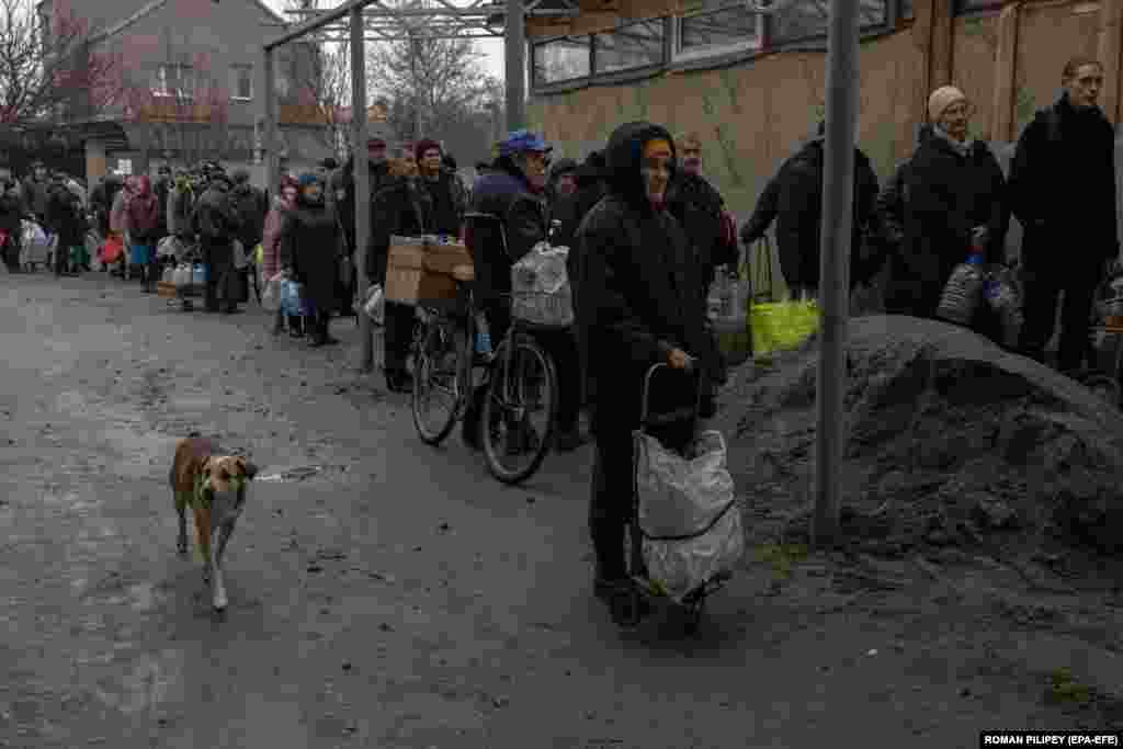 People wait in line to fill up bottles with drinking water from a well in Kherson, southern Ukraine.