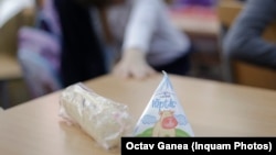 Elevii din România primesc alimente de la stat: un corn și o cutie cu lapte.