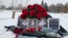 Цветы и портреты троих погибших на снегу на площади в Усть-Каменогорске. 5 января 2023 года