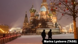 Doi oameni fotografiați mergând în apropiere de Catedrala Sfântul Vasile din Piața Roșie, în Moscova, Rusia, pe 22 noiembrie 2022.