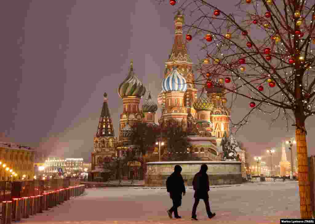 People walk past St Basil&#39;s Cathedral on Moscow&#39;s Red Square.