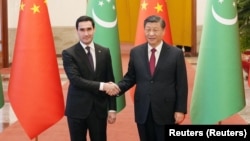 Chinese President Xi Jinping (right) and Turkmen President Serdar Berdymukhammedov shake hands at the Great Hall of the People in Beijing on January 6.