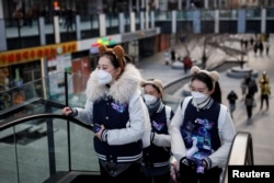 Посетительницы одного из торговых центров в Пекине. 3 января 2023 года