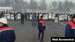 На кадре из видео — работники предприятия на фоне сил полиции. Тараз, 23 ноября 2022 года