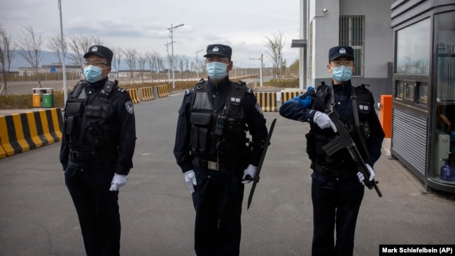 Police officers stand at the outer entrance of the Urumqi No. 3 Detention Center in Dabancheng in western China's Xinjiang Province in 2021.