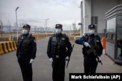Полицейские стоят у входа в центр заключения №3 Урумчи в Дабаньчэне в провинции Синьцзян на западе Китая в 2021 году