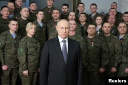 Okružen muškarcima i ženama u vojnim uniformama, ruski predsjednik Vladimir Putin obraća se naciji u svom godišnjem novogodišnjem govoru u sjedištu Južnog vojnog okruga u Rostovu na Donu 31. decembra 2022.