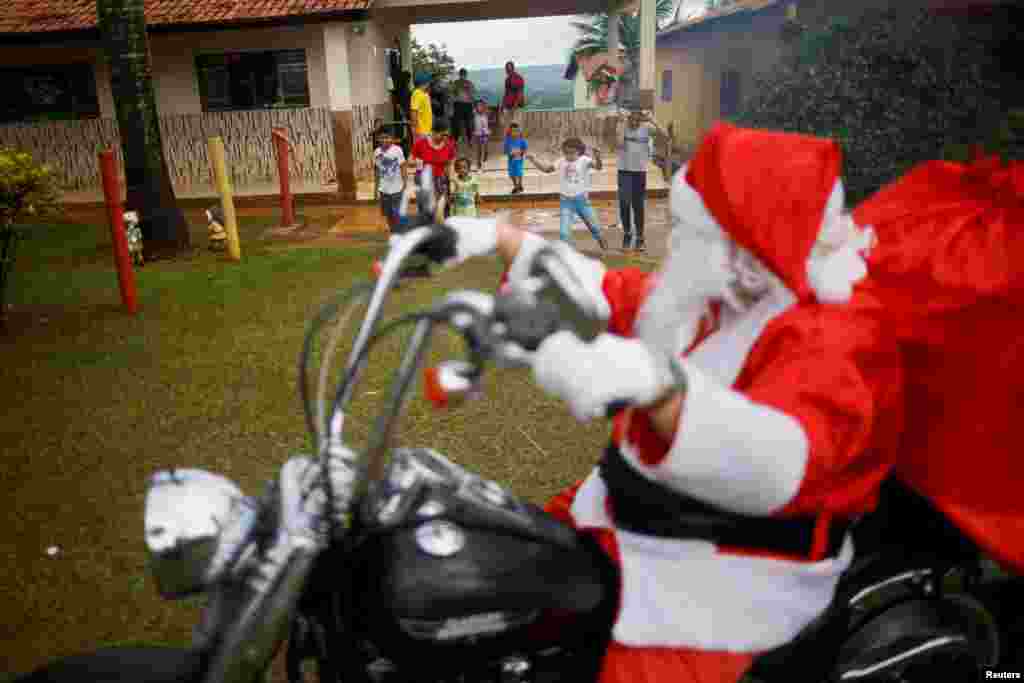 Санта-Клаус везет подарки на мотоцикле в деревенскую школу в Санту-Антониу-ду-Дескоберт, бразильский штат Гояс, 18 декабря.