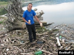 Un voluntar prezintă deșeurile pe care este nevoit să le strângă din Dunăre.