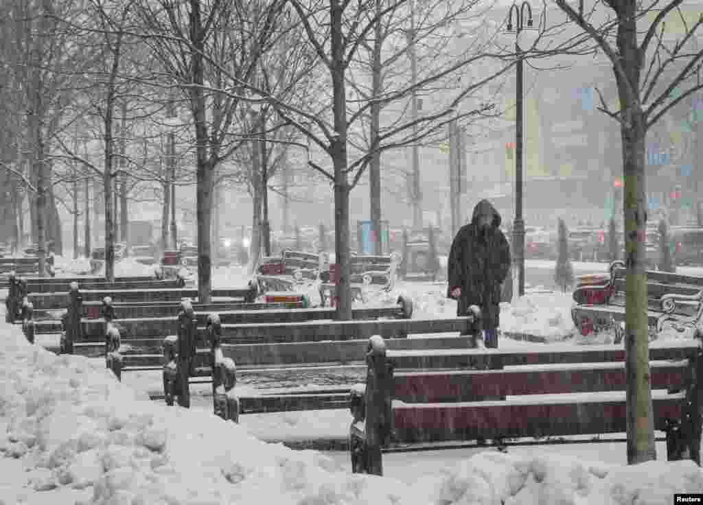 Një burrë duke ecur mes reshjeve të borës në Kiev ndërsa pushtimi rus i Ukrainës vazhdon, Ukrainë, 7 dhjetor 2022.&nbsp;