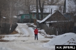 Жена върви по една от пустите улици на село Букачача.