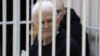 Nobel Prize winner Ales Byalyatski sits in the defendants' cage in the courtroom at the start of the hearing in Minsk on January 5.