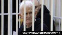 Nobel Prize winner Ales Byalyatski sits in the defendants' cage in the courtroom at the start of the hearing in Minsk on January 5.