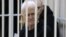Nobel Prize winner Ales Byalyatski sits in the defendants' cage in the courtroom at the start of the hearing in Minsk on January 5.