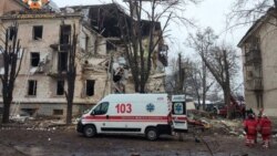 Un echipaj de ambulanță intervine după ce un bloc de locuințe a fost lovit de o bombă. 